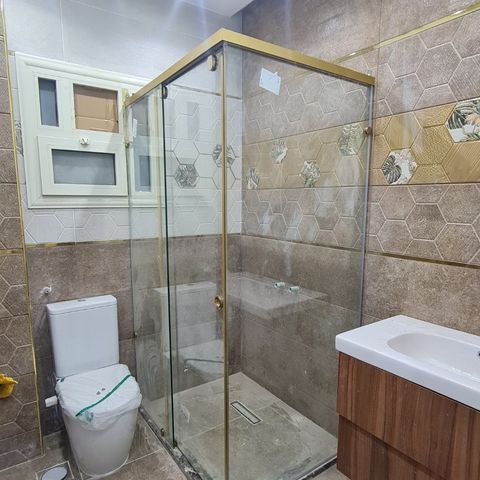 كابينة استحمام بإطار ذهبي